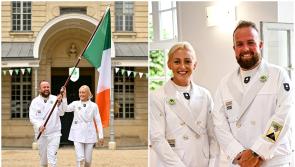 Shane Lowry agus Sarah Lavin le bratach na hÉireann a iompar ag na gCluichí Oilimpeacha