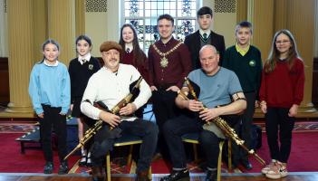 Is aíonna iad daltaí scoile ag ócáid Sheachtain na Gaeilge i Halla na Cathrach, Béal Feirste