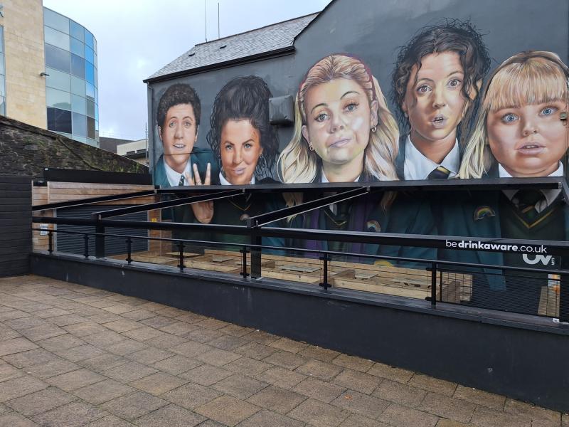 Athshuiteáil múrmhaisiú Derry Girls lá tar éis é a bhaint